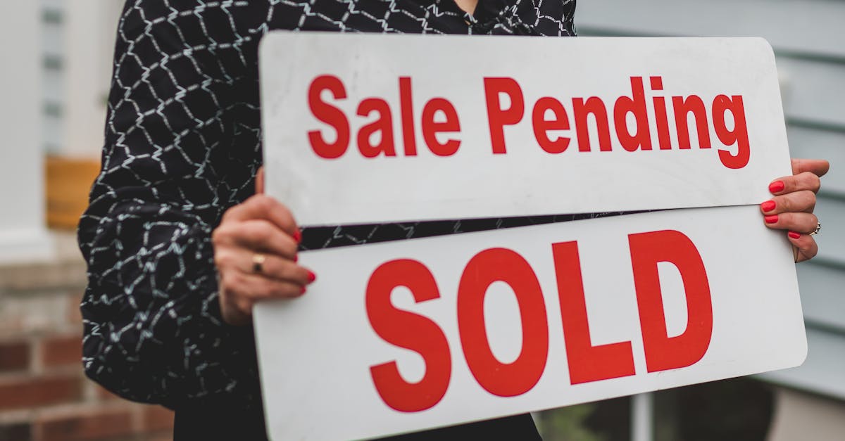 A businesswoman holding 'Sale Pending' and 'Sold' signs indicating a successful real estate transaction.